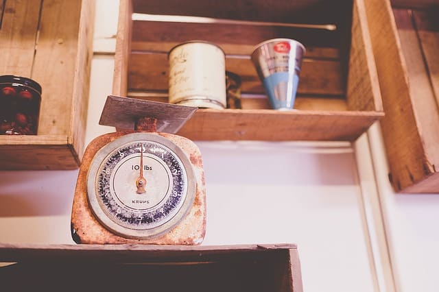 An antique kitchen scale sitting on a shelf