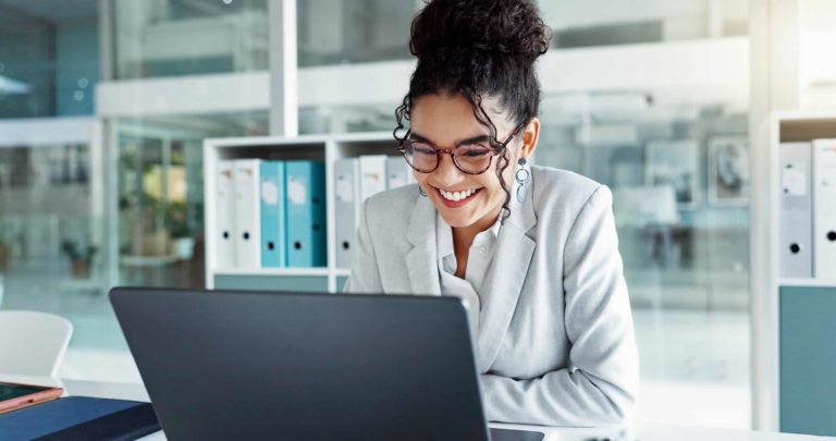 smiling woman sitting at her desk